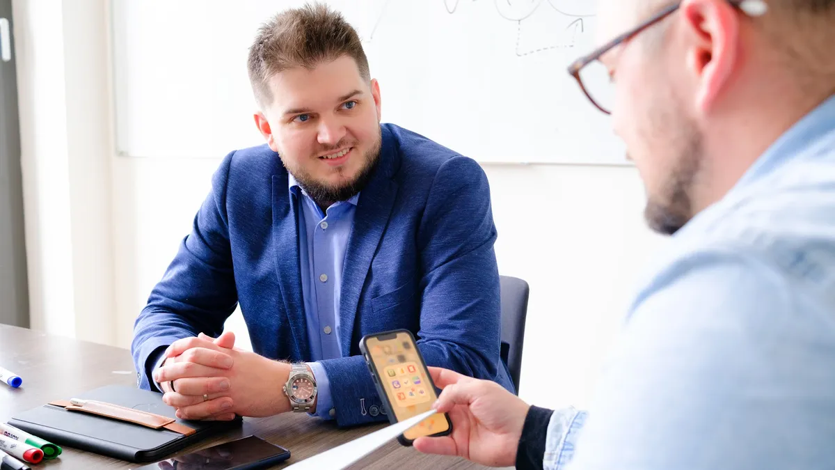 Martin Luňák na schůzce s klientem u stolu